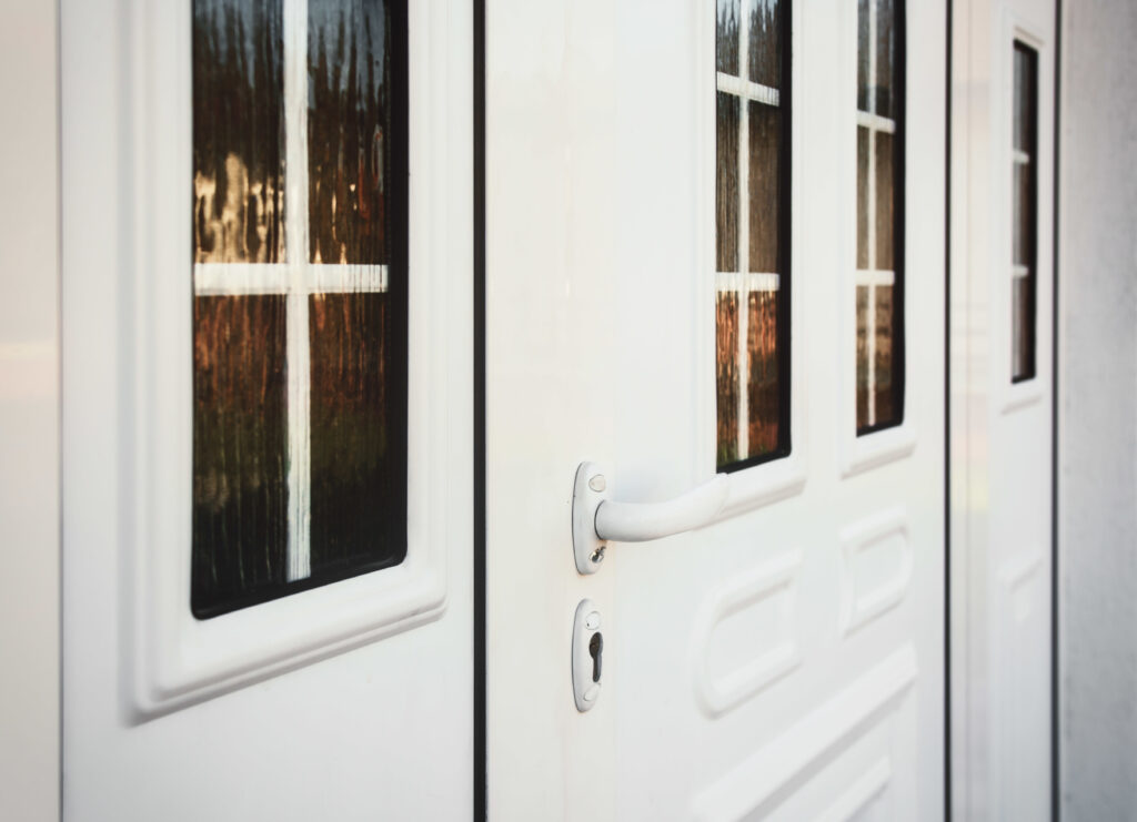 Up-close picture of white door with a lever knob to the front entrance of a home.