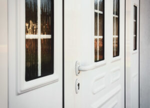 Up-close picture of white door with a lever knob to the front entrance of a home.