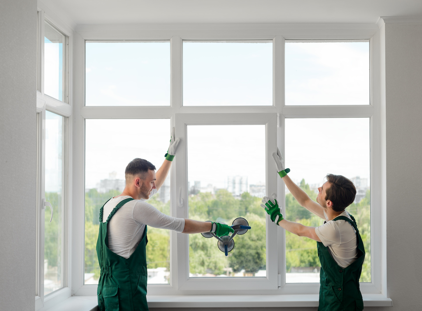 Construction workers install a window