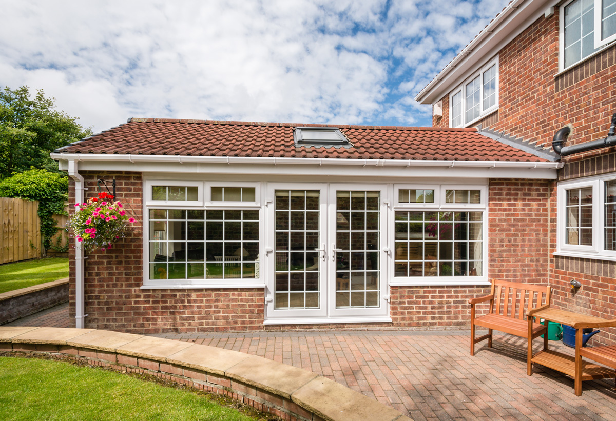 A brick El Paso home with white and glass patio doors.